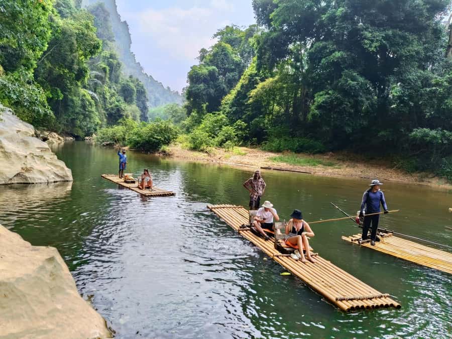 Khao Sok: Private Bamboo Rafting & Jungle Cave Temple Tour - Feeding fish beside the raft
